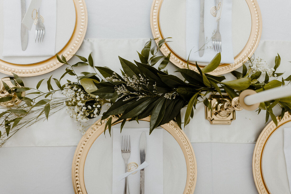 greenery along head table with gold and silver place settings
