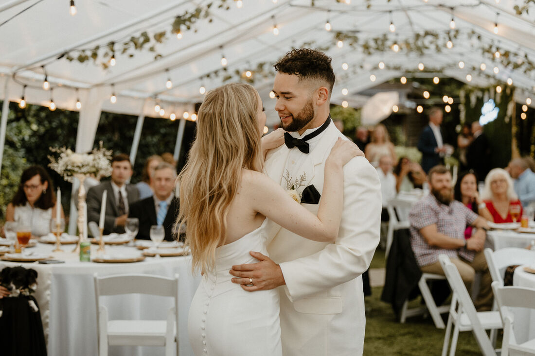bride and groom's first dance under tented reception