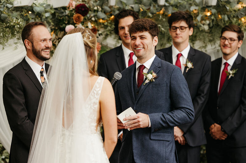 Groom laughing during vows at fall ceremony