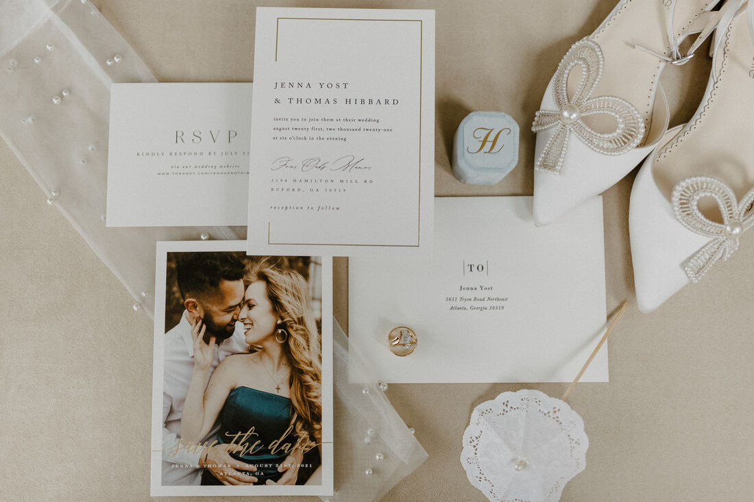 flat lay of white and gold classic wedding details