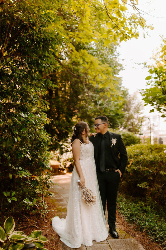 bride and groom posing in garden path