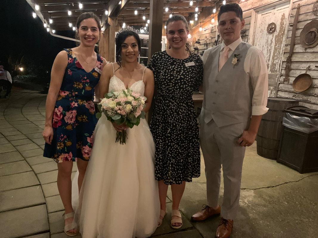 Four Oaks coordinators with bride and groom by smokehouse bar