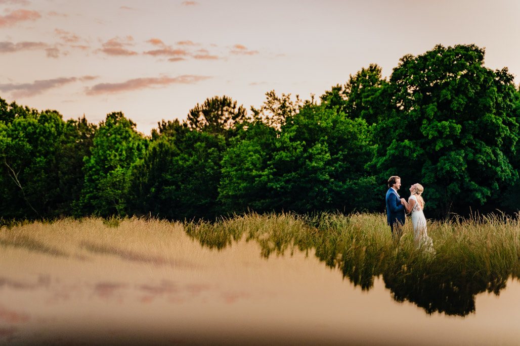 bride and groom in field with reflection effect