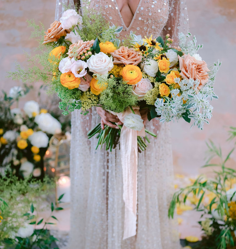 bride with large bouquet made up with white, blush, and orange flowers