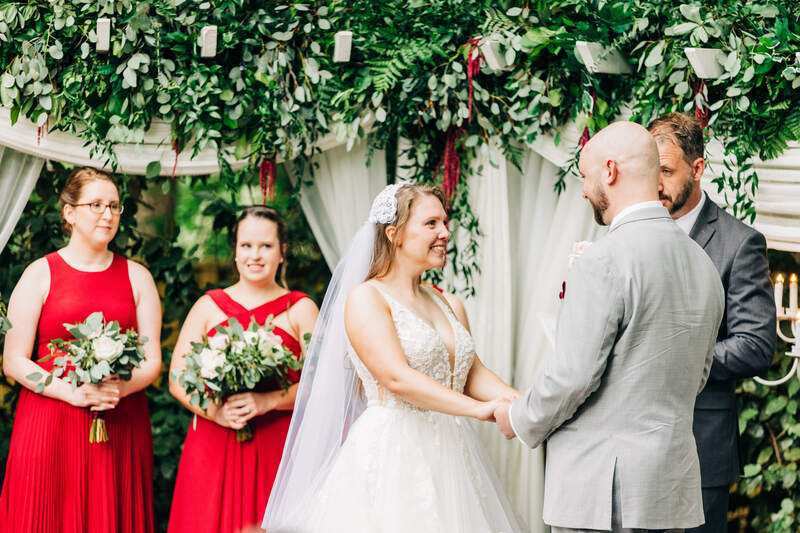 spring wedding ceremony with greenery and burgundy