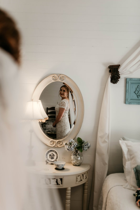 bride looking through vintage farmhouse mirror