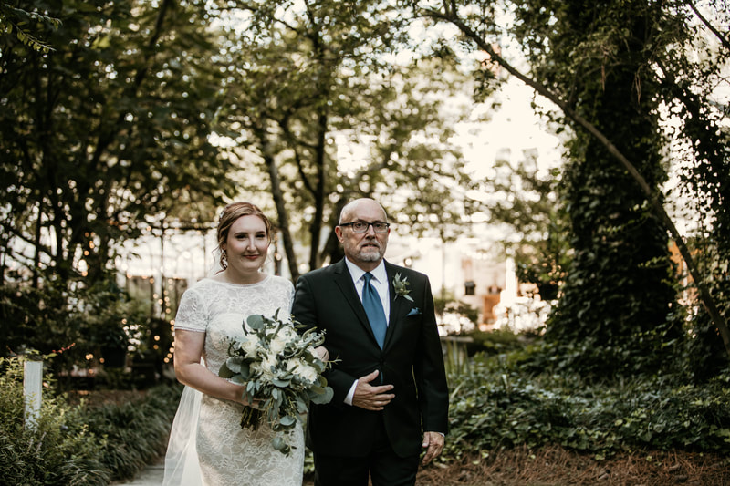 father of bride walking daughter down aisle during outdoor ceremony