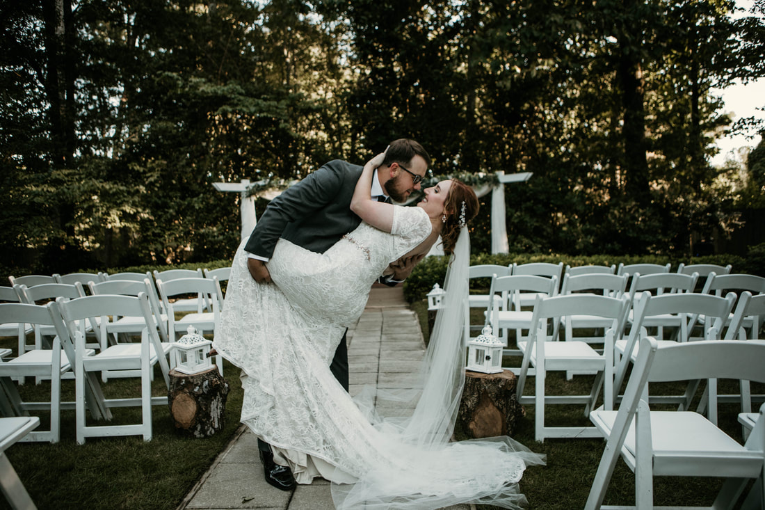groom dipping bride for kiss along ceremony path