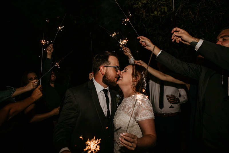 bride laughing during sparkler grand exit with groom