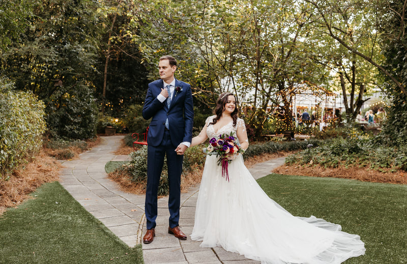 bride and groom posing along garden path