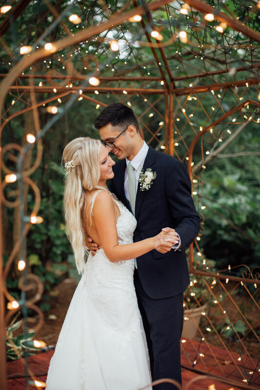 couples first dance in gazebo lit with string lights