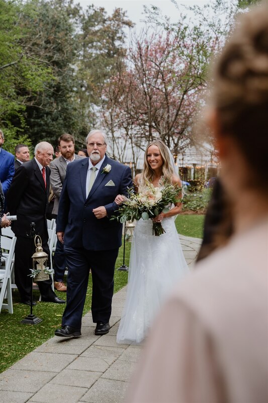bride walking down garden processional with father