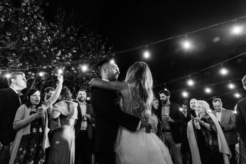 black and white photo of bride and groom dancing at outdoor venue