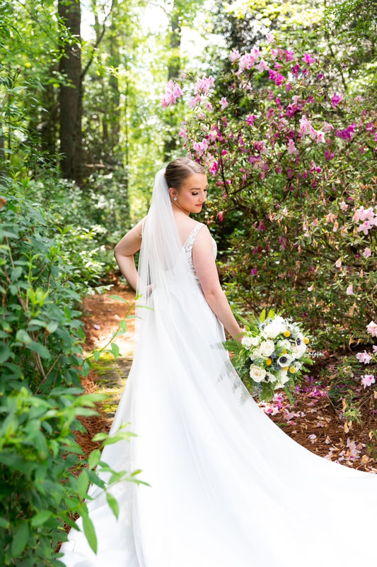 bride posing in garden with blooming azaleas 