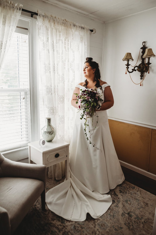 Bride posing upstairs with gothic wedding bouquet