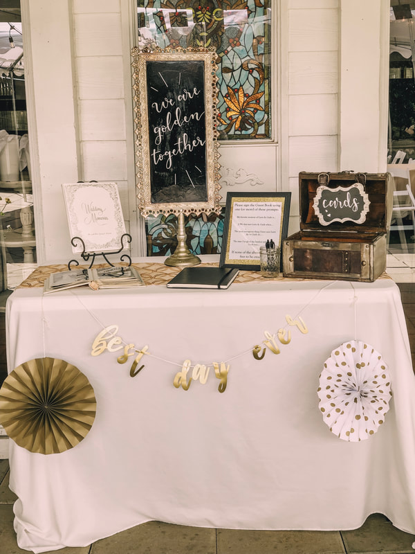 50th anniversary guestbook table with wedding photo album and gold decor