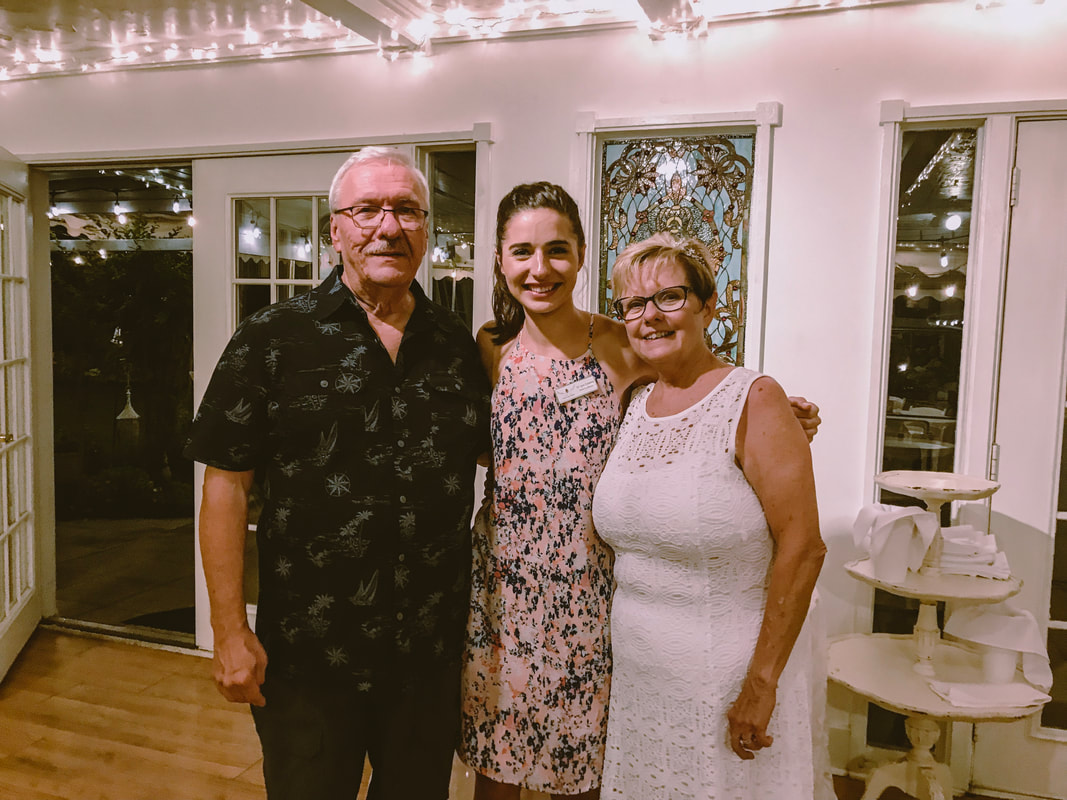 Four Oaks Marketing and event coordinator Morgan Cannova with older couple at rehearsal dinner in Carriage House.