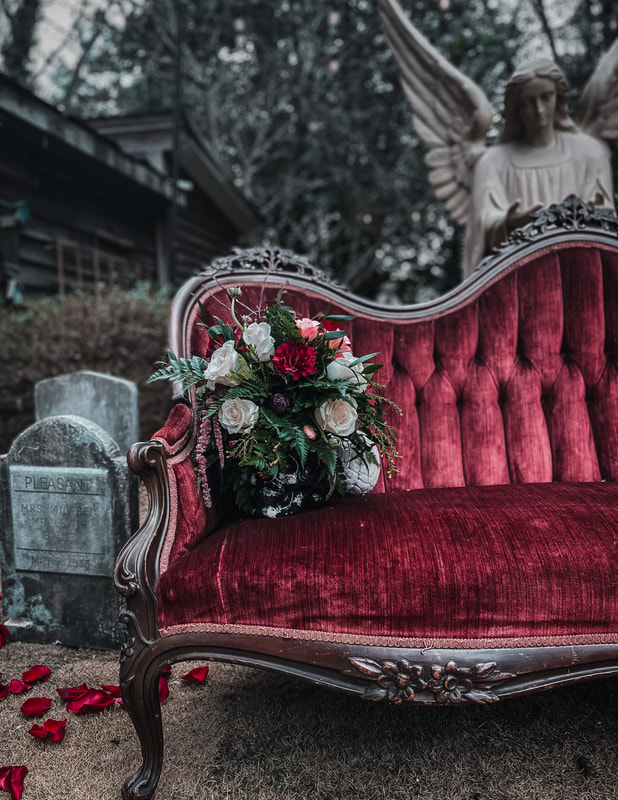 vintage velvet love seat with skull floral arrangement photobooth