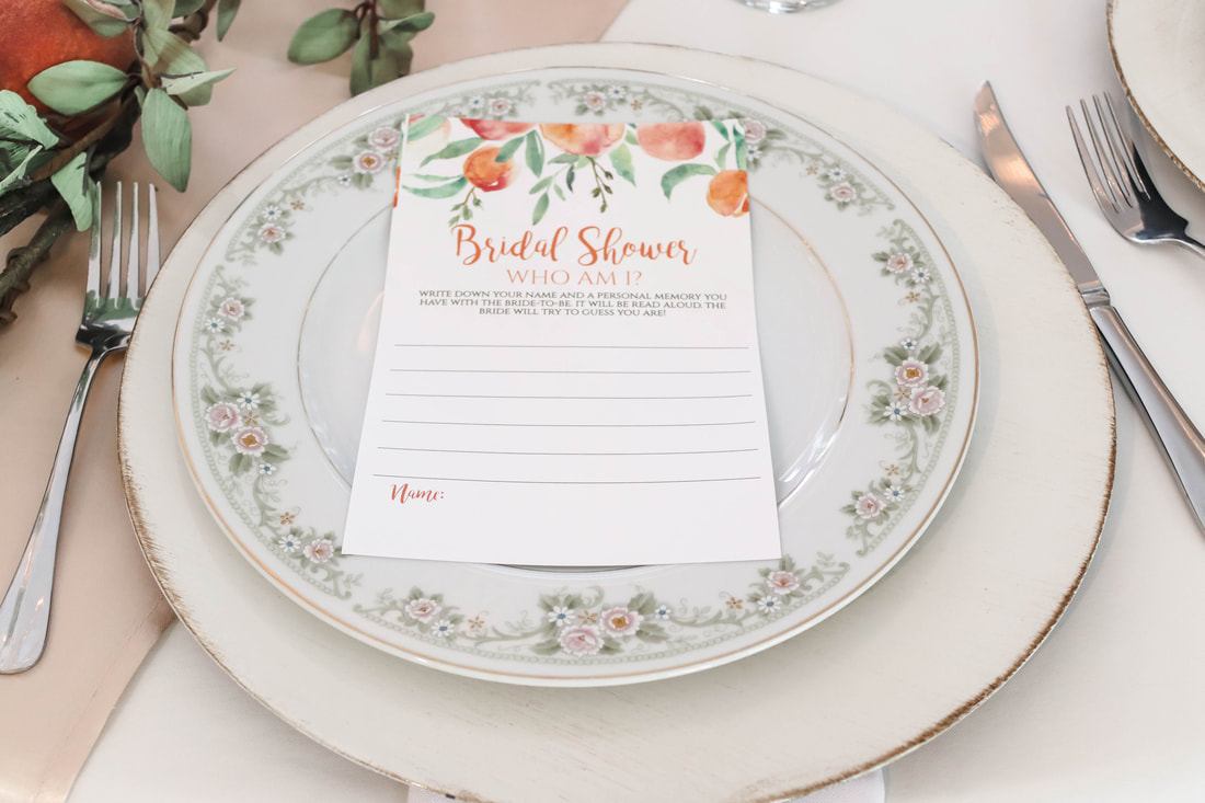 floral china on white charger with bridal shower game on top