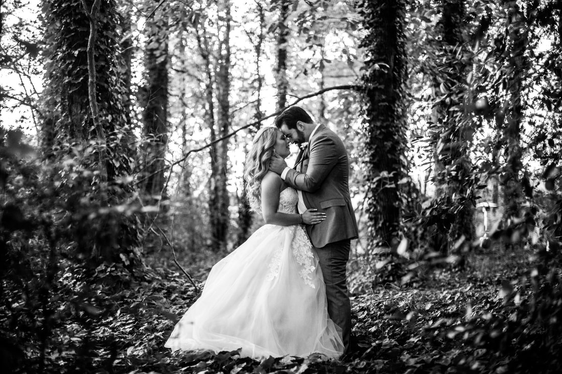 black and white photo of newlyweds among ivy and trees