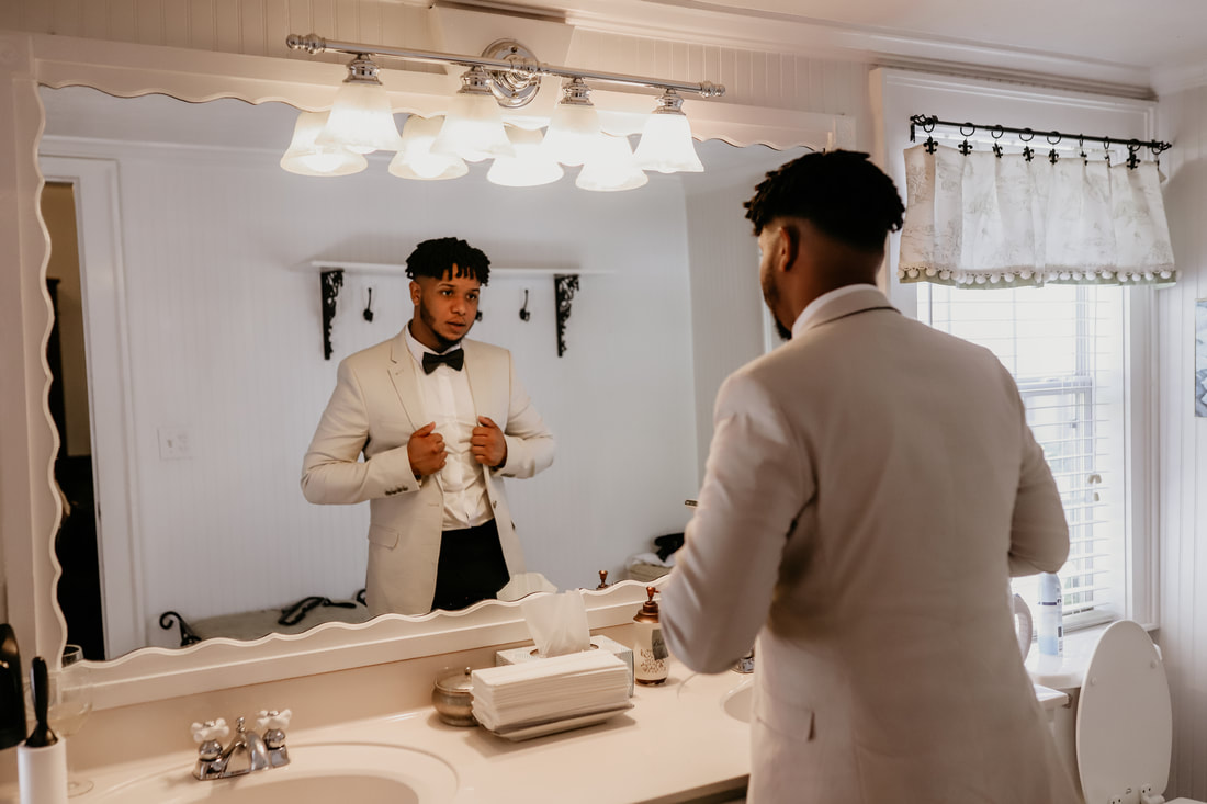 The groom checks that his suite looks o.k. in the groom's suite bathroom.