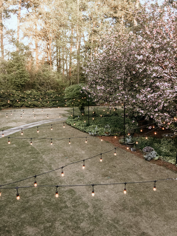 balcony view of Four Oaks' lawn with string lights hanging across
