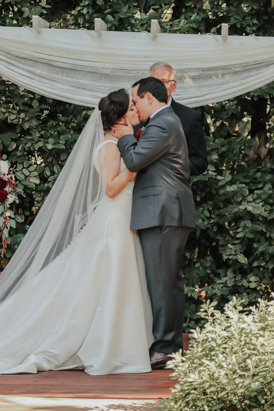 newlyweds kiss at outdoor altar