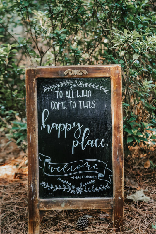 'To all who come to this happy place, welcome' Walt Disney quote on chalkboard sign
