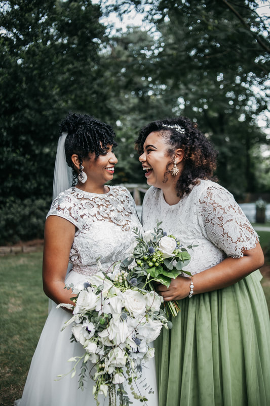 bride laughing with bridesmaid in lace dresses