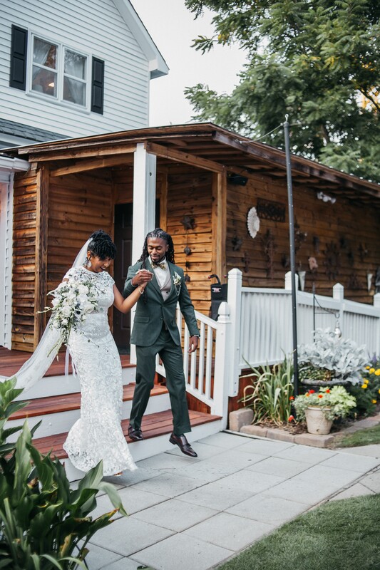 bride and groom walk down farmhouse porch steps after announcement