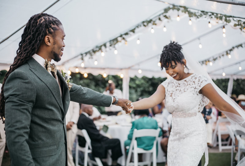 couple's first dance on outdoor dance floor under reception tents