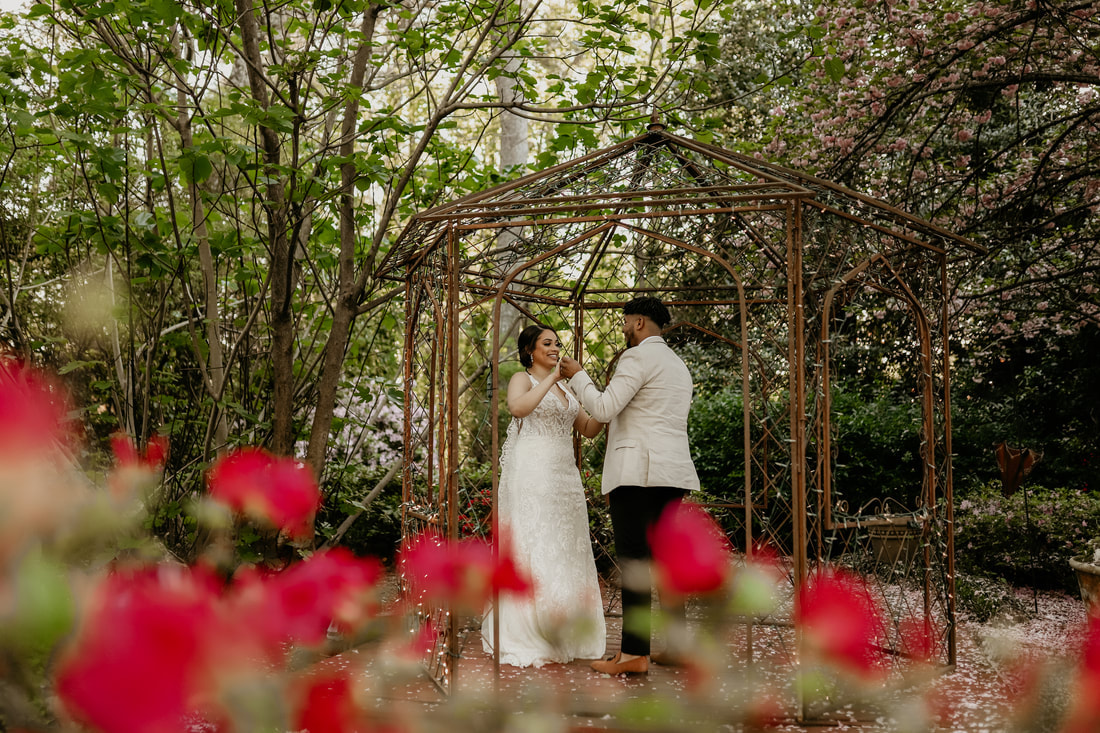 bride and groom's first dance in garden gazebo surrounded by spring flowers