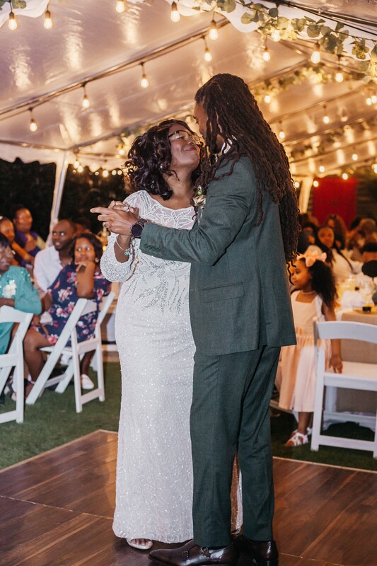 groom's first dance with mother in tented outdoor wedding reception