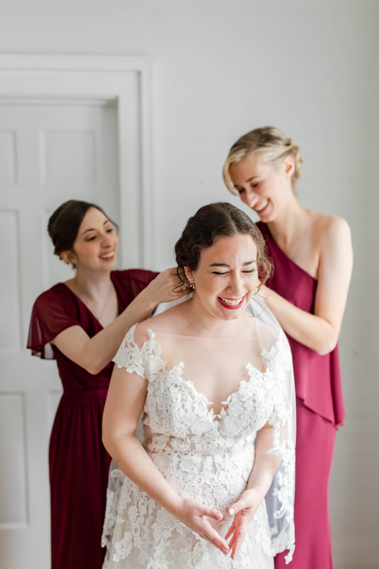 bridesmaids pinning bride's veil on 
