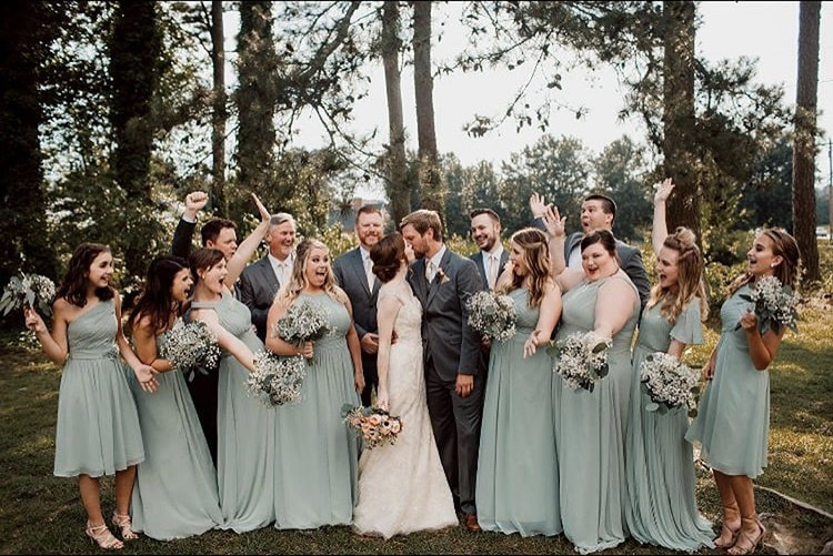 Bridal party cheers on married couple kissing