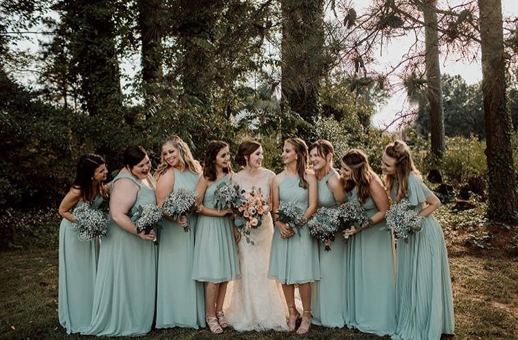 Bridesmaids smiling at bride while wearing mint blue dresses