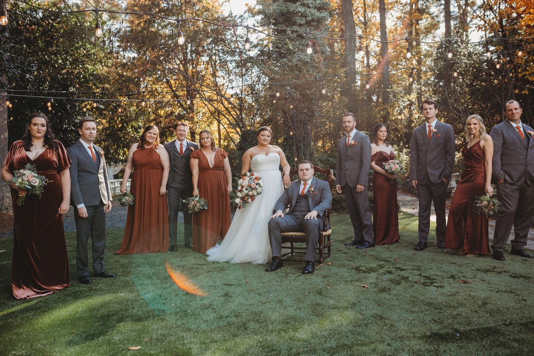 moody fall wedding party posing with bride and groom in outdoor venue
