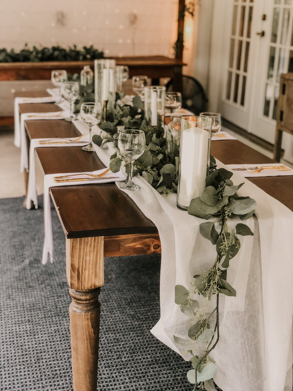 Farmhouse wedding table with white chiffon, eucalyptus, and candles