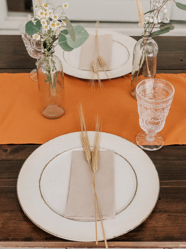 boho place setting with ivory charger, tan napkin, and wheat