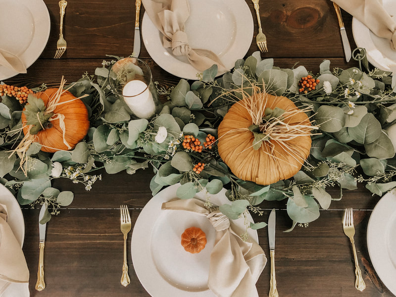 top shot of tablescape with rustic pumpkins in eucalyptus greenery