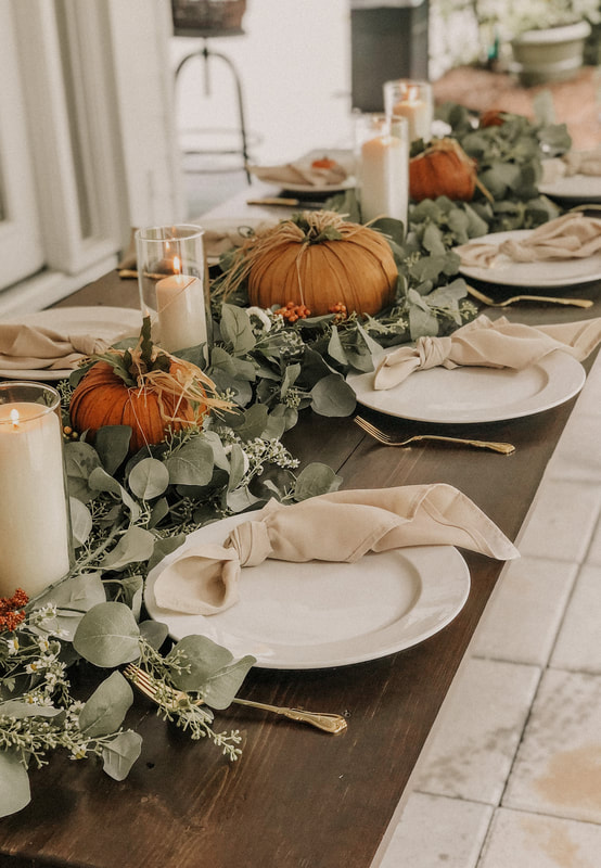 Dark stained farmhouse table with seeded eucalyptus and fall decorations