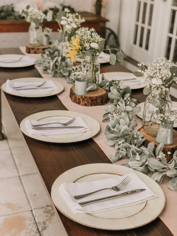 four oaks farmhouse table with ivory chargers and rustic centerpieces