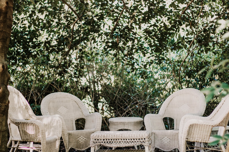 quiet sitting area with white wicker seats and tables