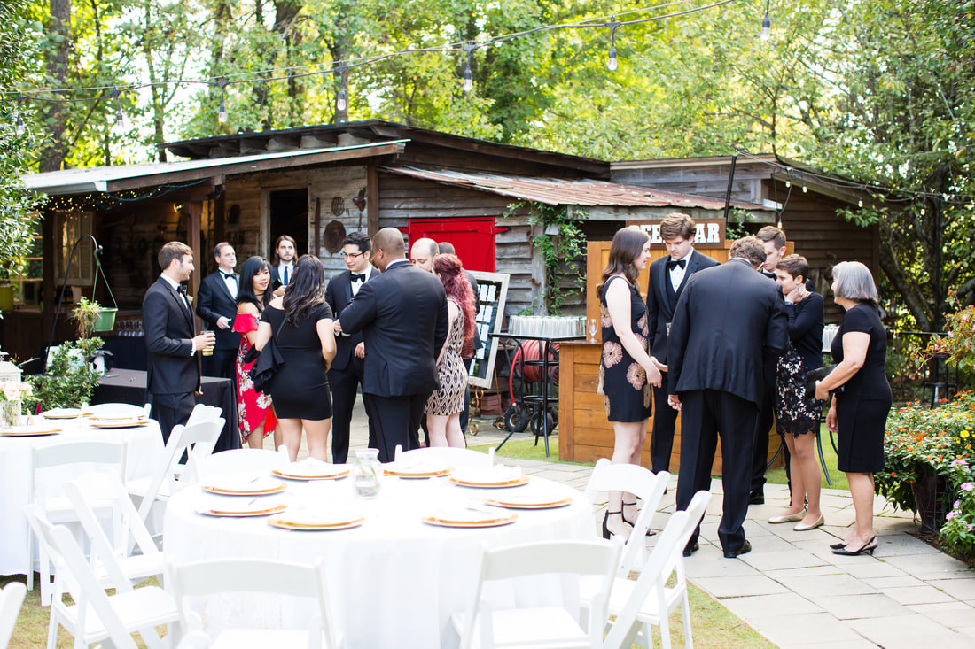 wedding guests at outdoor rustic barn getting drinks