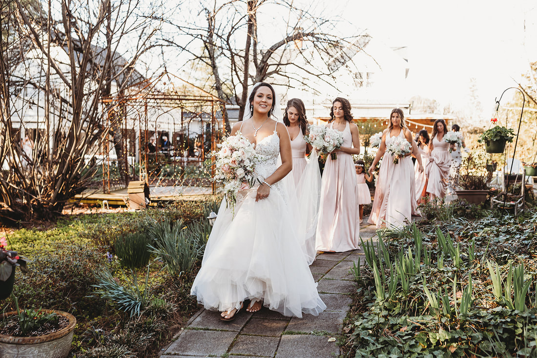 Bride followed by bridesmaids in soft pink dresses