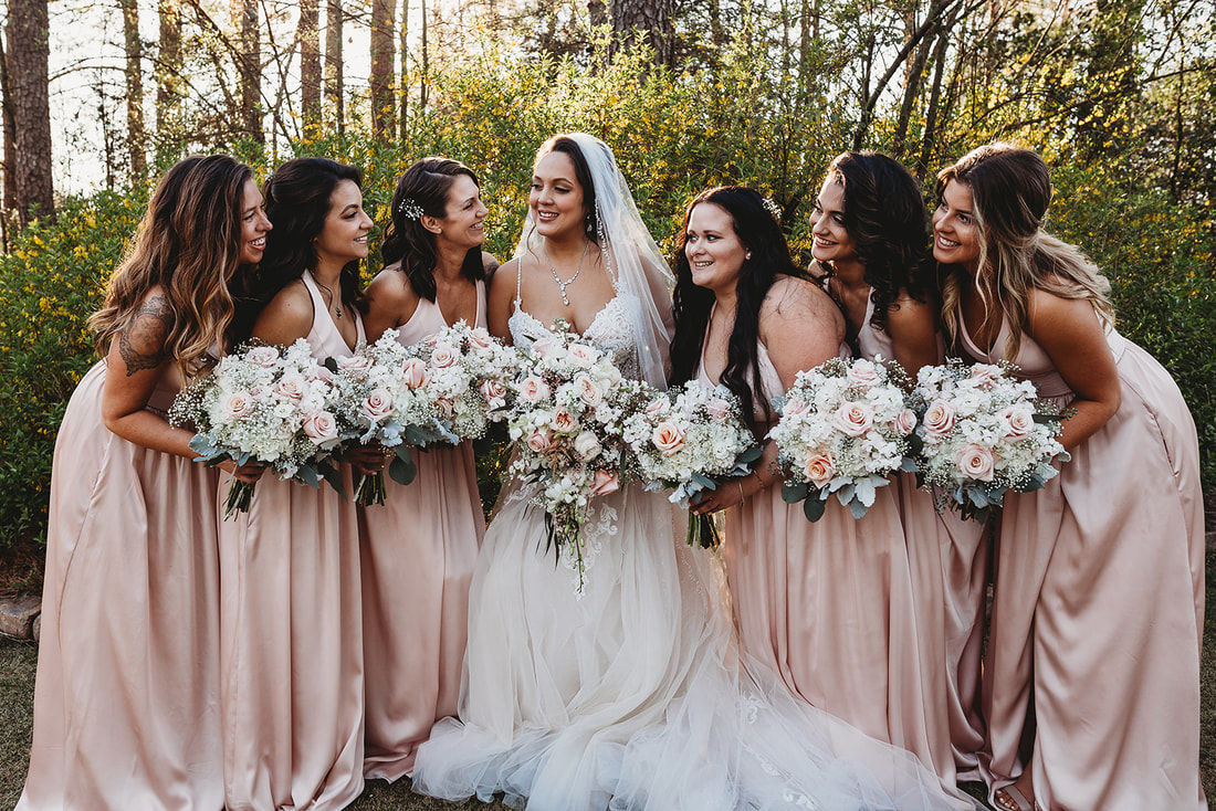 bride with her bridesmaids in champagne dresses with white and soft pink bouquets