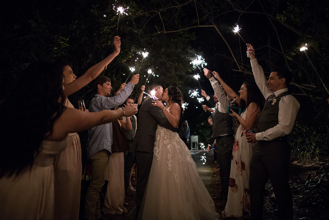 bride and groom sharing kiss during grand exit with sparklers