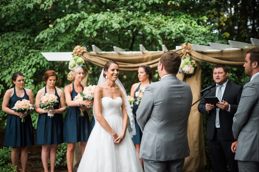 Wedding officiant speaking to couple and bridal party at ceremony