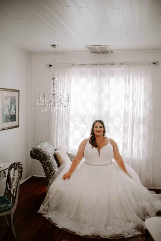 bride sitting on chaise lounge in bridal suite