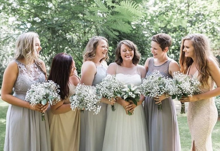 whimsical bridesmaids dresses with girls holding baby's breath and eucalyptus bouquets